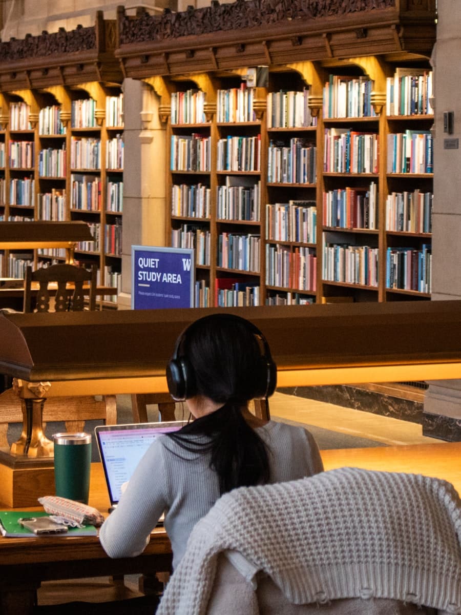 A student working at a laptop in a university library